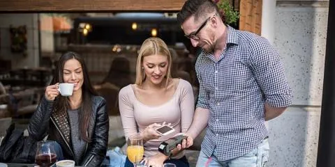 manlig entreprenör som underlättar kortbetalning för kvinnliga kunder manlig entreprenör som underlättar kortbetalning för kvinnliga kunder